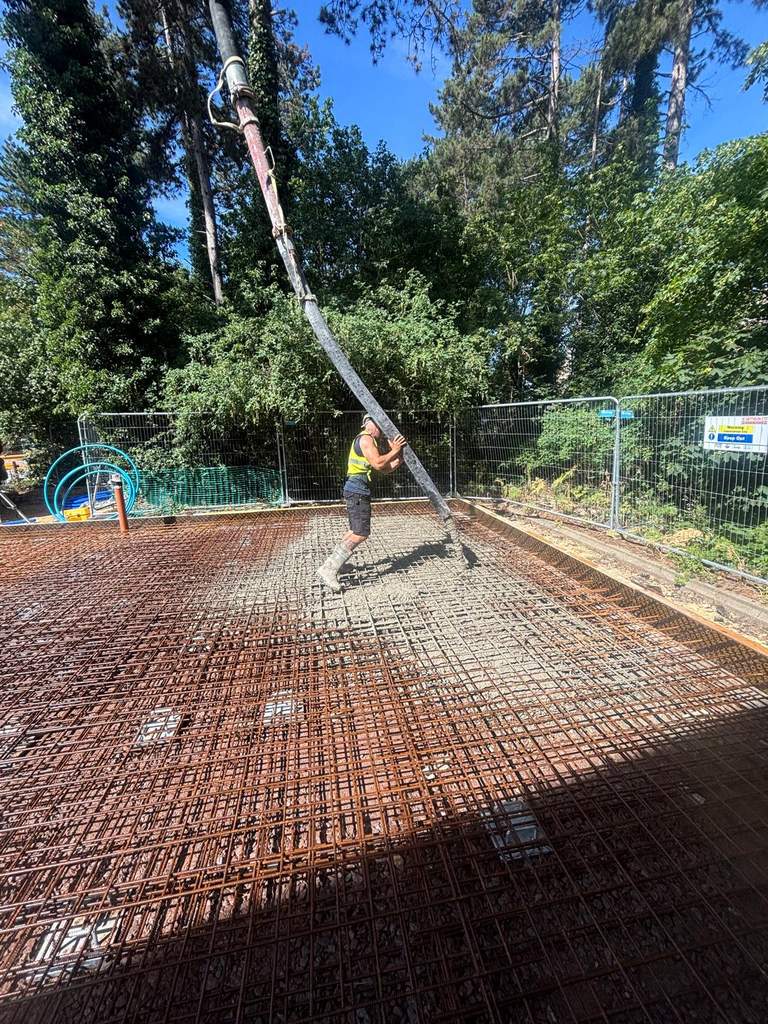 Operative guiding concrete pump boom over reinforced slab pour Cambridge — M.Smithson LTD