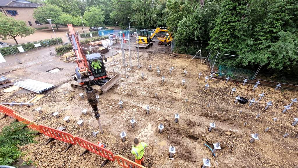 Aerial view of piling rig installing screw piles on site