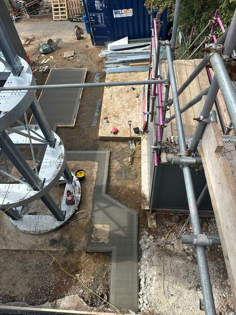 Freshly finished slab and paths wrapping the clad building