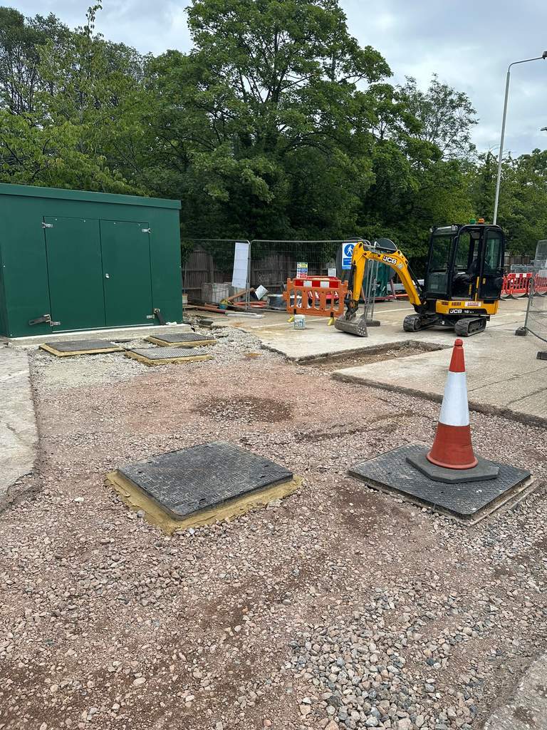 JCB mini excavator beside new utility chambers and cabinet