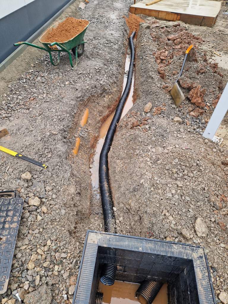 Ducting laid in open trench feeding new access chamber