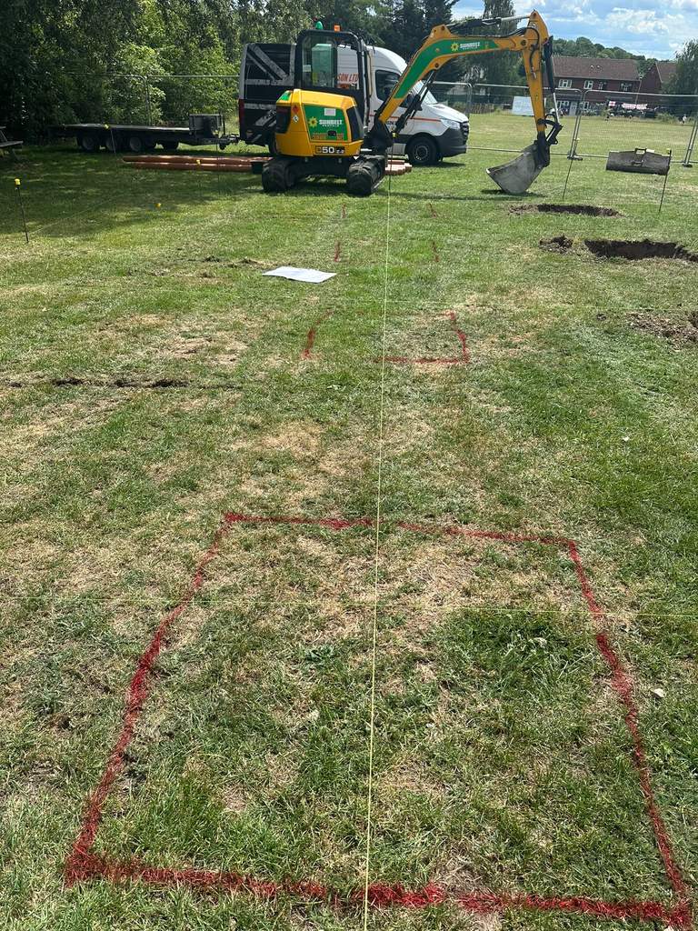 Foundation bases set out with string lines and excavator