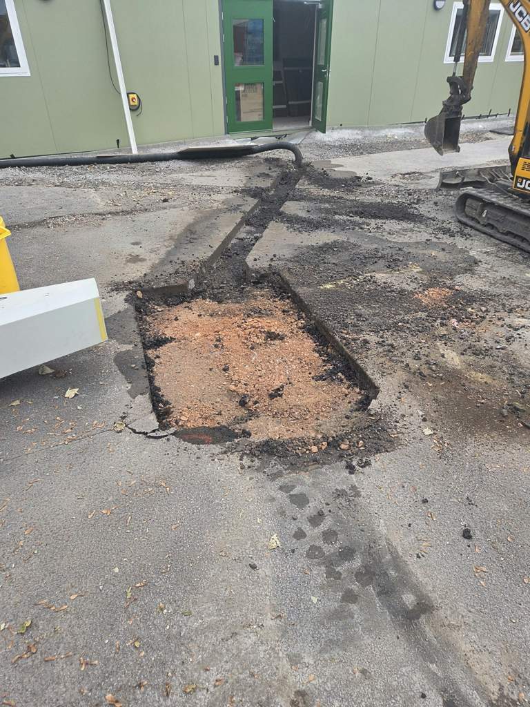 Breaking out tarmac for a new service trench with a mini excavator