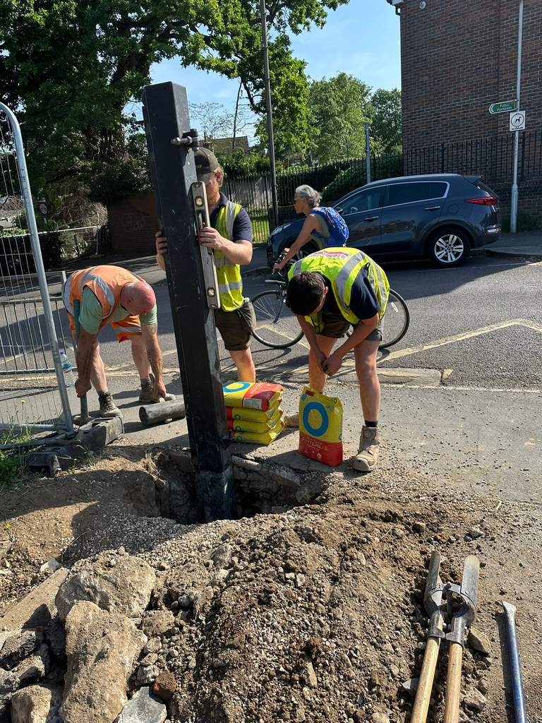 Crew levelling new steel gate post on street in Tonbridge Kent