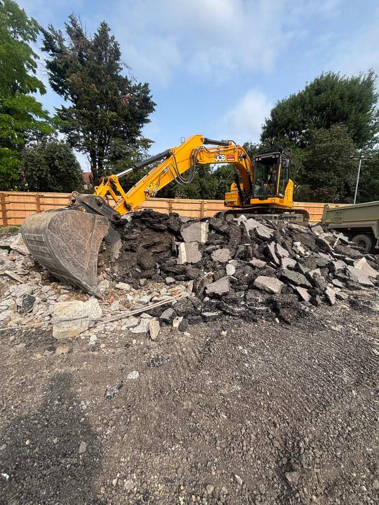 JCB tracked excavator loading broken tarmac Watford