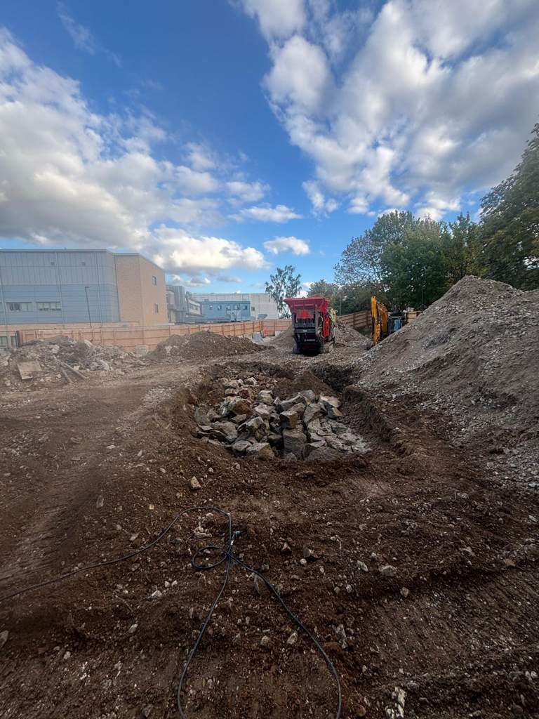 Excavator exposing buried concrete obstruction Watford
