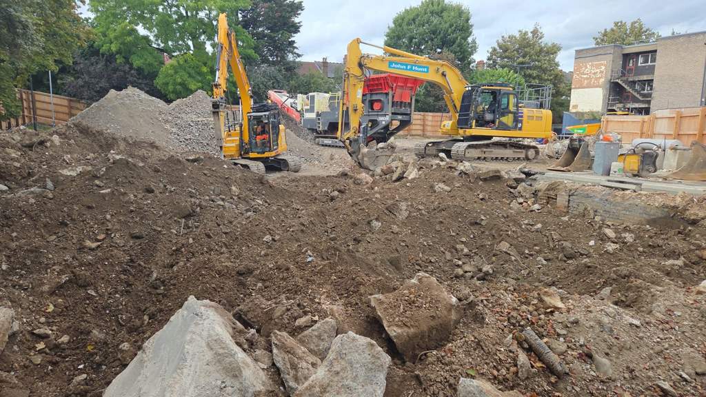 Excavators charging the crusher across the demolition platform